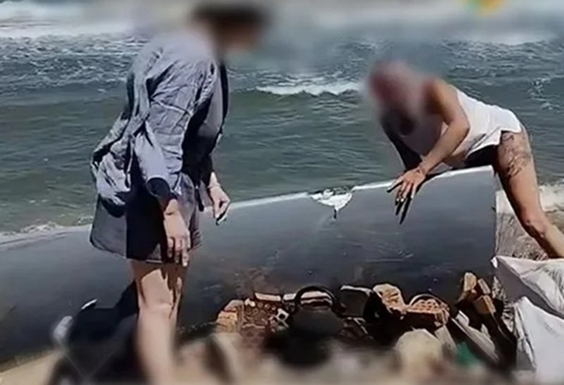 Отдыхающие на Кубани нашли крыло дрона и прикрыли им огонь от ветра на пляже Скриншот видео из соцсетей